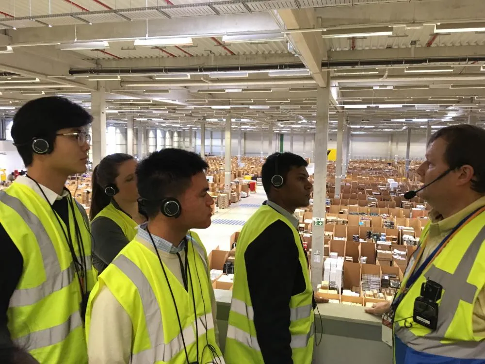 Students in an Amazon warehouse in Germany with an Amazon director